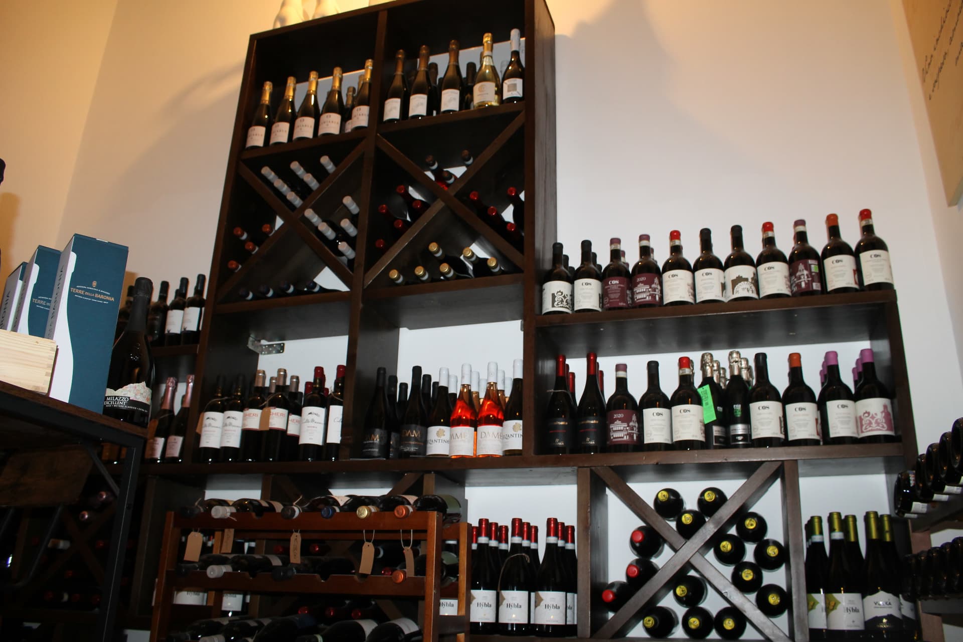 Grande parete cantina con bottiglie COS, Hybla e metodo classico