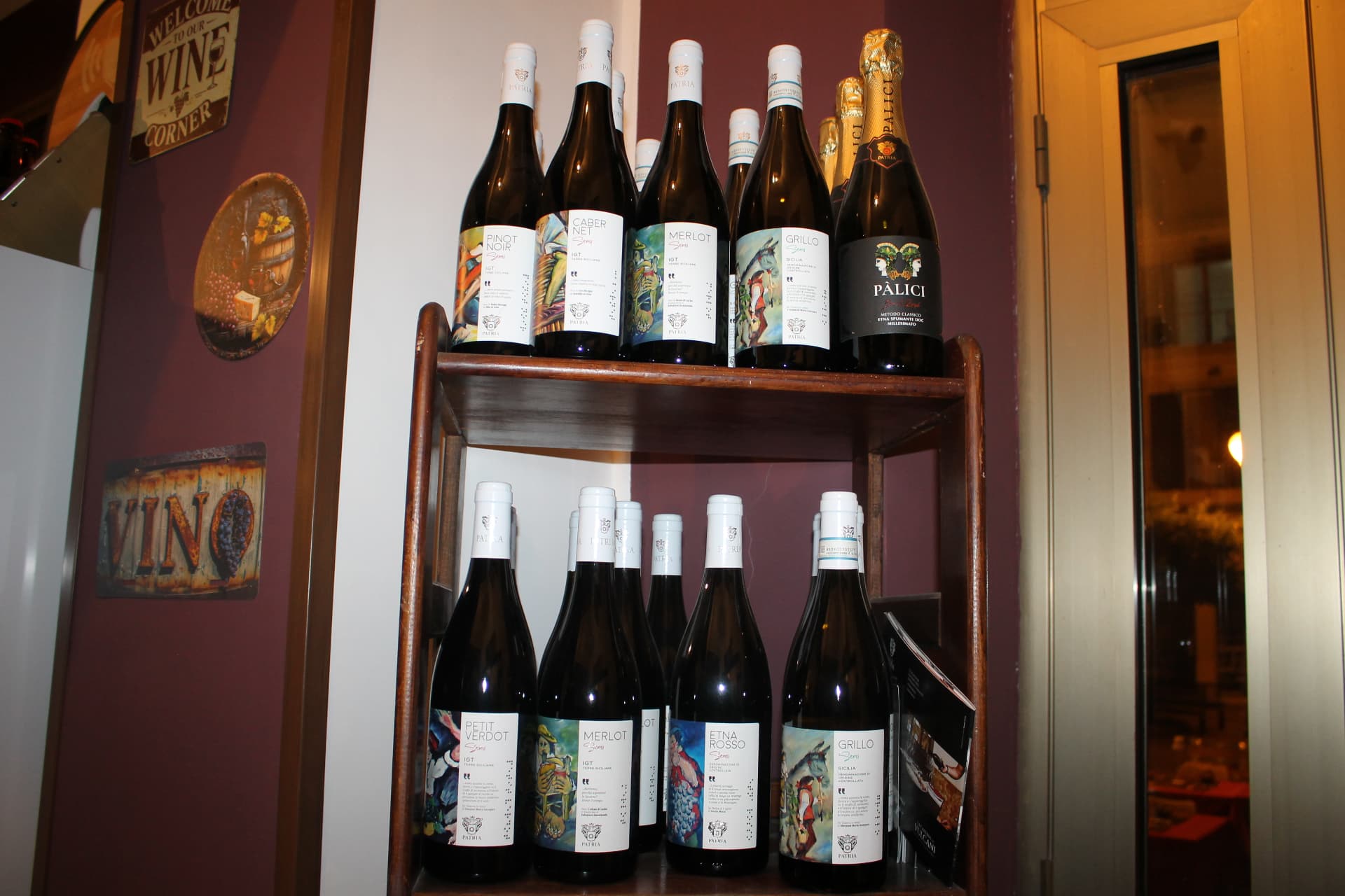 Scaffale con bottiglie Cantine Patria e metodo classico Pàlici